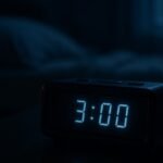 A bedside alarm clock glowing 3:00 AM in a dark bedroom, illustrating waking up in the middle of the night
